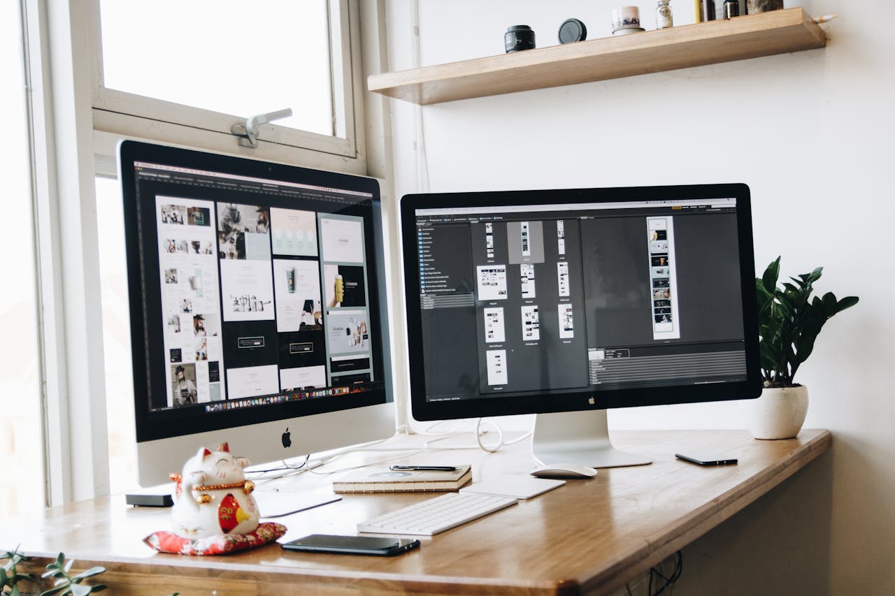 A clean, organized workspace featuring dual monitors, ideal for productivity and creative work.